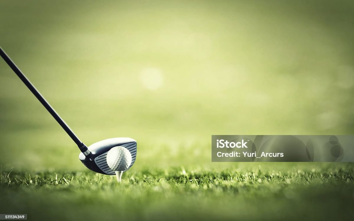 A golf club ready to tee-off with a white ball on a golf course